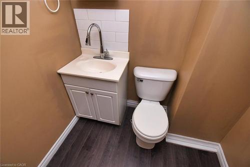 Compact powder room featuring a white vanity with integrated sink, chrome faucet, and white subway tile backsplash - 522 Aberdeen Avenue, Hamilton, ON - Indoor Photo Showing Bathroom