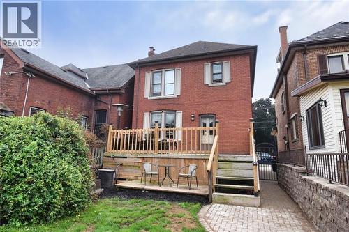 Rear exterior featuring a brick facade, multi-level wood deck, ground-level patio, and a stone paver path - 522 Aberdeen Avenue, Hamilton, ON - Outdoor With Deck Patio Veranda With Exterior