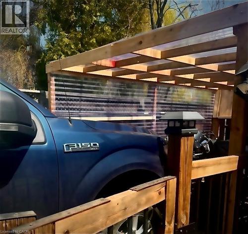 Wood-framed carport with a clear corrugated panel roof and side panels, featuring a wooden railing and a post-mounted light fixture - 522 Aberdeen Avenue, Hamilton, ON -  Photo Showing Other Room