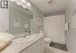 Full bathroom featuring a vanity with a white oval undermount sink, a patterned countertop, and chrome faucet fixtures - 