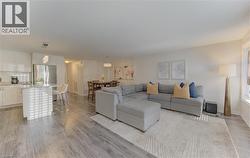Open-concept living space featuring wood-finish flooring, white walls, and recessed lighting - 