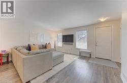 Bright living space featuring wood-finish flooring and a neutral color palette - 