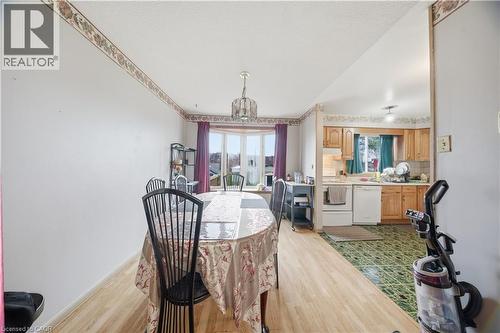 Dining area featuring wood-finish flooring, a bay window with purple drapes, and an overhead chandelier - 116 Gainsborough Road, Hamilton, ON - Indoor Photo Showing Dining Room