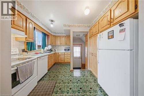 Kitchen with ample wood cabinetry, white appliances, and a tiled countertop - 116 Gainsborough Road, Hamilton, ON - Indoor Photo Showing Kitchen