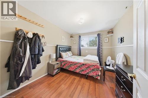 Bedroom featuring wood-finish flooring, a neutral wall color with white trim, and a window with a dark curtain rod - 116 Gainsborough Road, Hamilton, ON - Indoor Photo Showing Bedroom