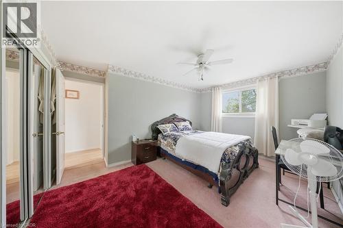 Bedroom featuring a ceiling fan, wall-to-wall carpeting, and a window with white curtains - 116 Gainsborough Road, Hamilton, ON - Indoor Photo Showing Bedroom