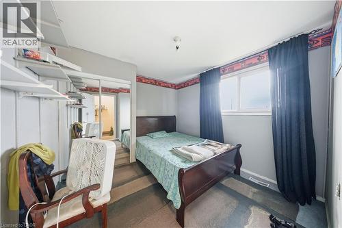 Bedroom featuring a double window with dark curtains, light gray walls, and a mirrored closet door - 116 Gainsborough Road, Hamilton, ON - Indoor Photo Showing Bedroom