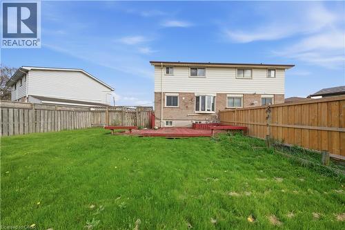 Expansive grassy lawn with a red-stained wooden deck - 116 Gainsborough Road, Hamilton, ON - Outdoor