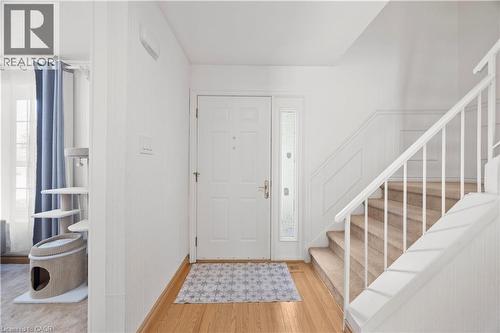 Entryway featuring a paneled door with a sidelight, hardwood flooring, and a carpeted staircase with white railings - 277 Blackacres Boulevard, London, ON - Indoor Photo Showing Other Room