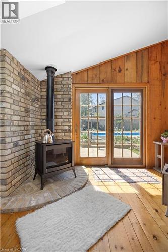Wood-finish flooring with a brick-surround gas fireplace and a brick hearth - 277 Blackacres Boulevard, London, ON - Indoor