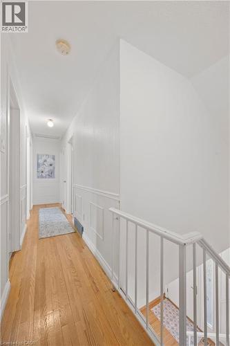 Hallway featuring wood flooring, white paneling, and a white staircase railing - 277 Blackacres Boulevard, London, ON - Indoor Photo Showing Other Room