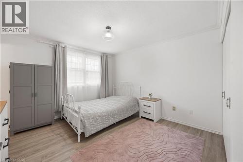 White walls with crown molding, wood-finish flooring, and a flush mount ceiling light fixture - 277 Blackacres Boulevard, London, ON - Indoor Photo Showing Bedroom