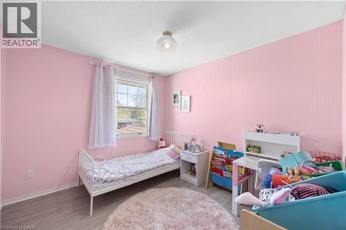 Bright room featuring wood-finish flooring, a white ceiling, and a prominent window with white trim - 277 Blackacres Boulevard, London, ON - Indoor Photo Showing Bedroom