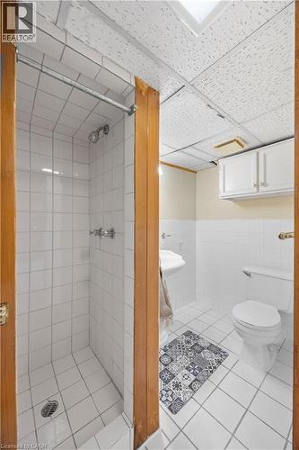 Bathroom featuring a white tile shower enclosure with chrome fixtures, a pedestal sink, and a toilet - 277 Blackacres Boulevard, London, ON - Indoor Photo Showing Bathroom