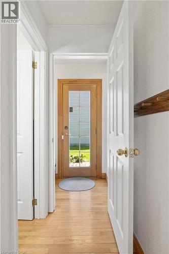 Foyer featuring light wood-finish flooring, white paneled doors, and a natural wood-framed glass-paned entry door with brass hardware - 277 Blackacres Boulevard, London, ON - Indoor Photo Showing Other Room