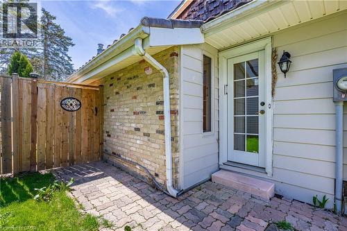 Side patio area featuring brick pavers and a wood privacy fence with decorative insert - 277 Blackacres Boulevard, London, ON - Outdoor With Exterior
