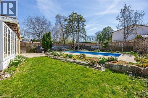 Private backyard oasis featuring an in-ground pool, surrounding concrete patio, and a stone-lined garden bed - 277 Blackacres Boulevard, London, ON - Outdoor With In Ground Pool With Backyard