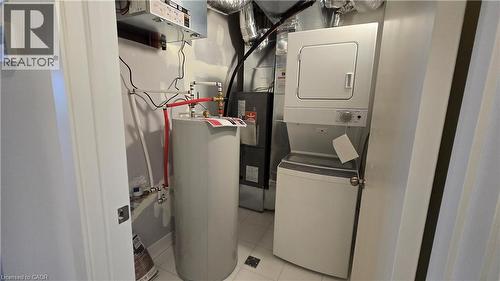 Dedicated utility space featuring a stacked washer and dryer, water heater, and HVAC system - 16 Melbourne Avenue Unit# 210B, St. Catharines, ON - Indoor Photo Showing Laundry Room