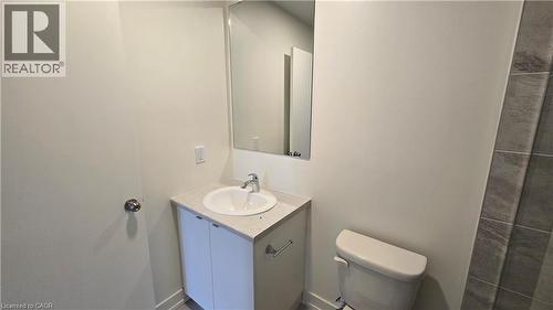 Bathroom featuring a white vanity with an undermount sink, a chrome faucet, and a light-toned countertop - 16 Melbourne Avenue Unit# 210B, St. Catharines, ON - Indoor Photo Showing Bathroom