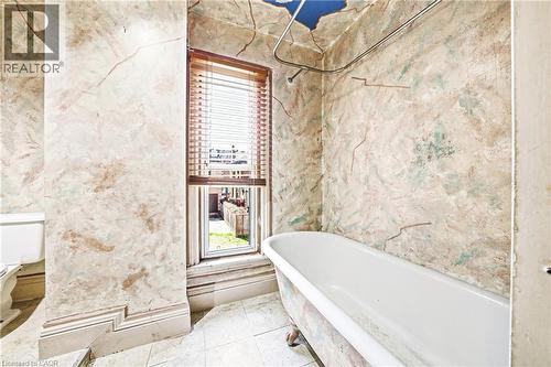 Freestanding clawfoot tub with a shower curtain rod - 116 Catharine Street S, Hamilton, ON - Indoor Photo Showing Bathroom
