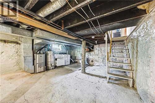 Basement space featuring exposed ceiling joists and ductwork, a concrete floor, stone foundation walls, and a utility area with mechanical systems - 116 Catharine Street S, Hamilton, ON - Indoor Photo Showing Basement