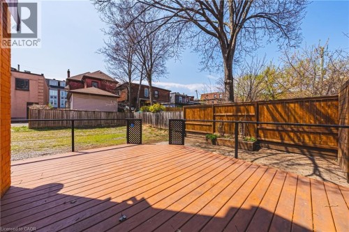 Expansive outdoor deck featuring wood decking, black metal railings, and a privacy fence - 116 Catharine Street S, Hamilton, ON - Outdoor With Deck Patio Veranda