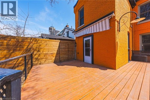 Spacious outdoor deck featuring wood-finish flooring and a privacy fence - 116 Catharine Street S, Hamilton, ON - Outdoor With Exterior