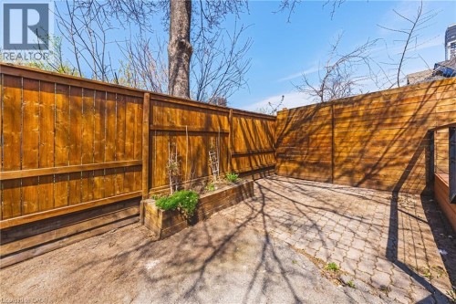Private outdoor space featuring a paver patio and stained wood fencing - 116 Catharine Street S, Hamilton, ON - Outdoor