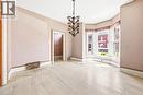 Room featuring a prominent bay window with natural light, light wood-finish flooring, and a decorative multi-arm chandelier - 116 Catharine Street S, Hamilton, ON  - Indoor Photo Showing Other Room 