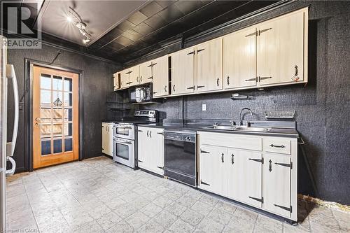 Kitchen featuring light-toned cabinetry with strap hinges, a stainless steel double oven, and a built-in dishwasher - 116 Catharine Street S, Hamilton, ON - Indoor Photo Showing Kitchen With Double Sink