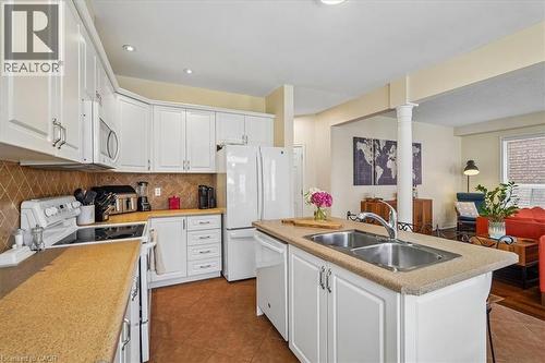 Open-concept kitchen featuring white cabinetry, contrasting countertops, and a double basin sink - 4679 Webb Street, Burlington, ON - Indoor Photo Showing Kitchen With Double Sink