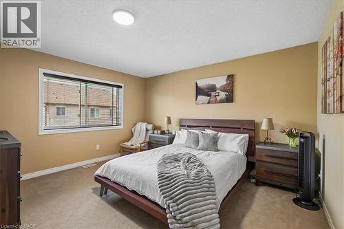 Carpeted room featuring a large window with horizontal blinds, a white ceiling, and a flush-mount ceiling light - 4679 Webb Street, Burlington, ON - Indoor Photo Showing Bedroom