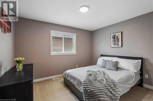 Bedroom featuring neutral wall paint, a white-framed window with blinds, carpet flooring, and a flush-mount ceiling light fixture - 4679 Webb Street, Burlington, ON - Indoor Photo Showing Bedroom