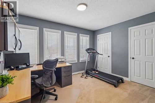 Versatile room featuring three windows with blinds, neutral carpeting, and a built-in desk with upper cabinetry - 4679 Webb Street, Burlington, ON - Indoor Photo Showing Office