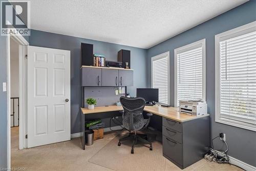 Room featuring three windows with blinds, a six-panel door, and built-in shelving with lower cabinetry - 4679 Webb Street, Burlington, ON - Indoor Photo Showing Office