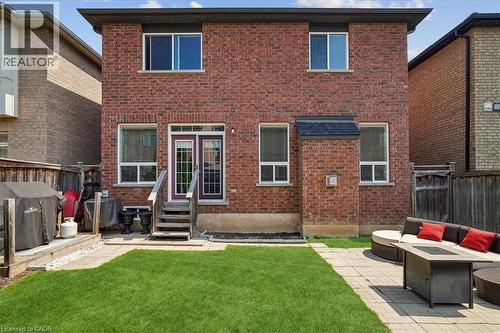 Brick exterior featuring multiple windows and a rear entry with French doors - 4679 Webb Street, Burlington, ON - Outdoor With Exterior