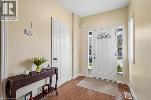 Entryway with terra cotta-toned tile flooring, a white paneled front door with an arched transom, and surrounding sidelight windows - 4679 Webb Street, Burlington, ON - Indoor Photo Showing Other Room