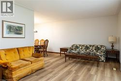 Spacious living area featuring contemporary wood-finish flooring and neutral wall tones - 