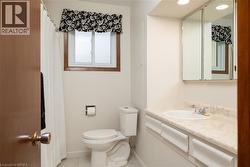 Bathroom featuring a single vanity with an integrated sink, a mirrored medicine cabinet, recessed lighting, and a window with wood-finish trim - 