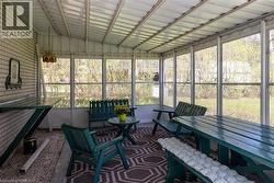 Screened porch with extensive window panels, white brick exterior wall, and a full ceiling - 