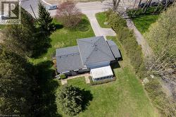Expansive property featuring a grey asphalt shingle roof, enclosed porch, and a large grassy yard - 