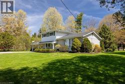 Expansive green lawn with mature trees bordering the property - 