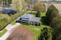 Two-story residence with a light gray exterior, featuring a covered front porch and an attached carport - 