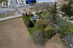 Expansive lot featuring mature trees, a detached single-story residence, and a paved driveway - 