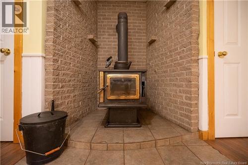 Beautiful brick hearth and woodstove for added comfort and warmth in winter - 8 Dane Row, Willow Grove, NB - Indoor Photo Showing Other Room