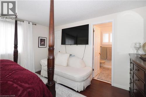 Bedroom with wood finished floors, connected bathroom, and a textured ceiling - 89 Lynnhaven Court, Kitchener, ON - Indoor Photo Showing Bedroom