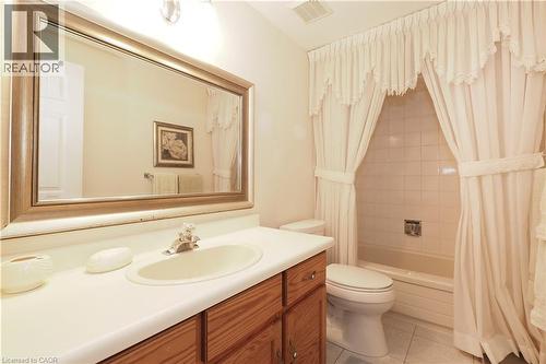 Full bathroom featuring vanity, shower / bath combo with shower curtain, and light tile patterned flooring - 89 Lynnhaven Court, Kitchener, ON - Indoor Photo Showing Bathroom