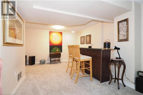 Indoor dry bar featuring light colored carpet and dark countertops - 89 Lynnhaven Court, Kitchener, ON - Indoor