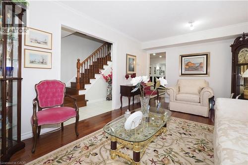 Living area with dark wood-style floors and ornamental molding - 89 Lynnhaven Court, Kitchener, ON - Indoor Photo Showing Living Room
