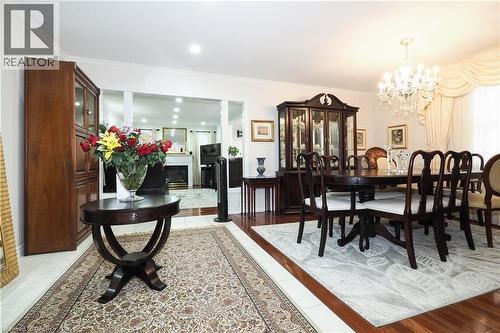 Dining room with hanging lights, crown molding, and a fireplace - 89 Lynnhaven Court, Kitchener, ON - Indoor Photo Showing Dining Room